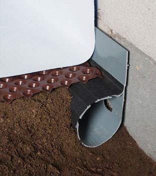 Closeup of a crawl space drainage system installed in Stinnet