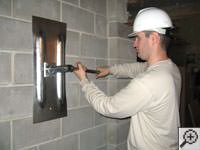 Attempting to straighten a bowed foundation wall by straightening a wall anchor system in a Borger home.