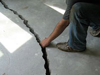 a severely damaged cracked concrete slab floor in Spearman