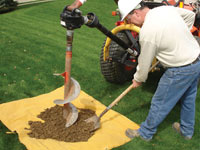 Auguring a hole in the earth for a foundation wall repair system in Borger