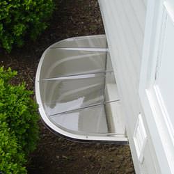 A vinyl basement window and covered window well in Shamrock